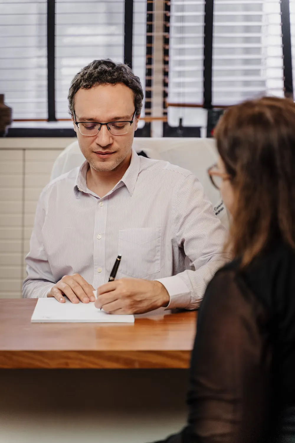 Dr. Felipe Carvalho fazendo anotações durante uma consulta